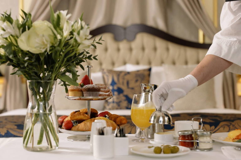 Room service - person setting up breakfast at a table