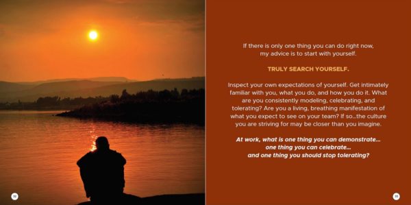 Silhouette of person sitting by a lake watching sunset